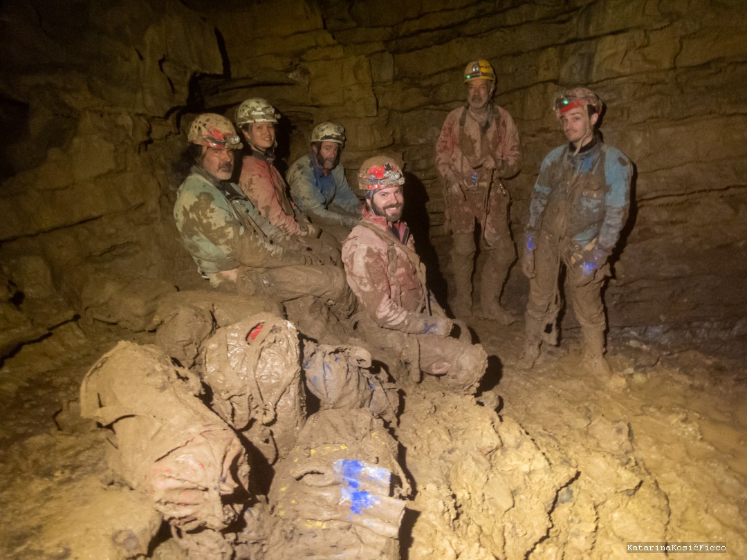 Group in the cave covered in mud after a long day.