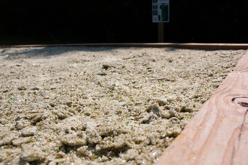A tee box along the Thistle Ridge Disc Golf Trail using recycled glass for sand