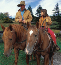 Dad and daughter with horses.