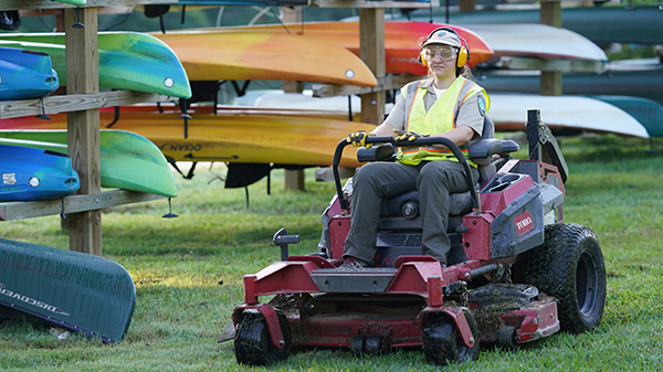 Female ranger cutting grass